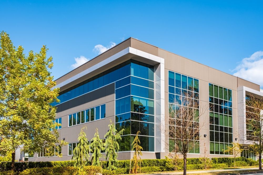 A large building with a lot of windows and trees in front of it.