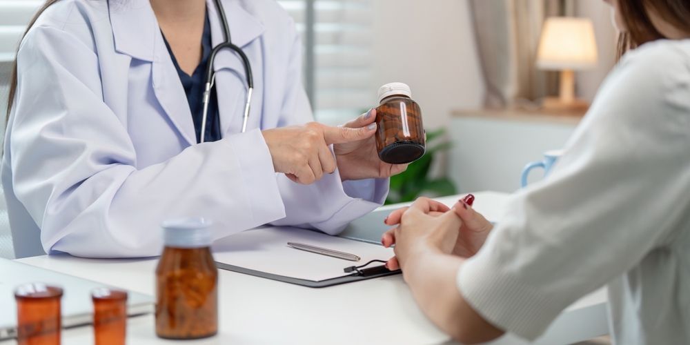 A doctor is giving a bottle of pills to a patient.