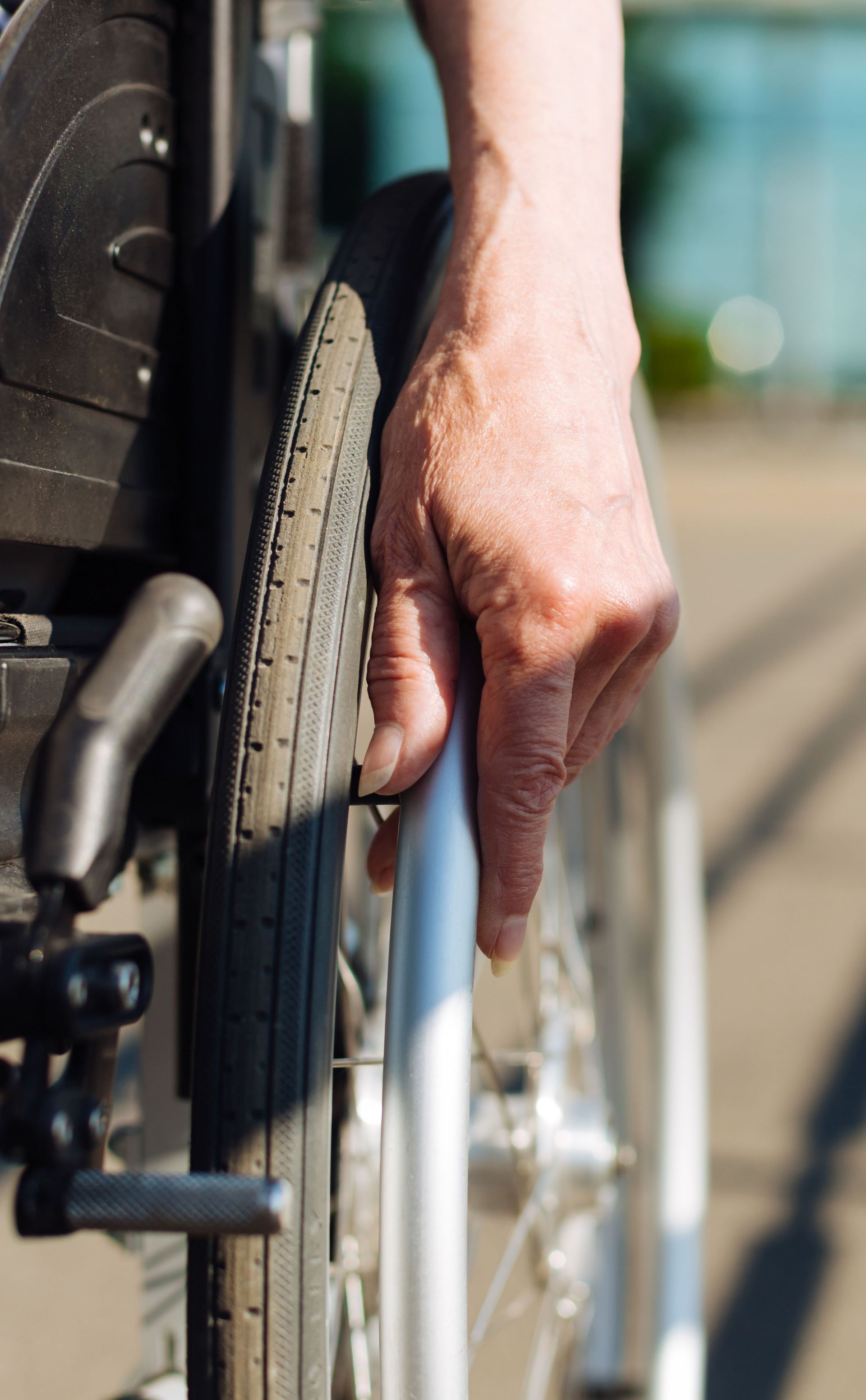 A close up of a person 's hand on a wheelchair.