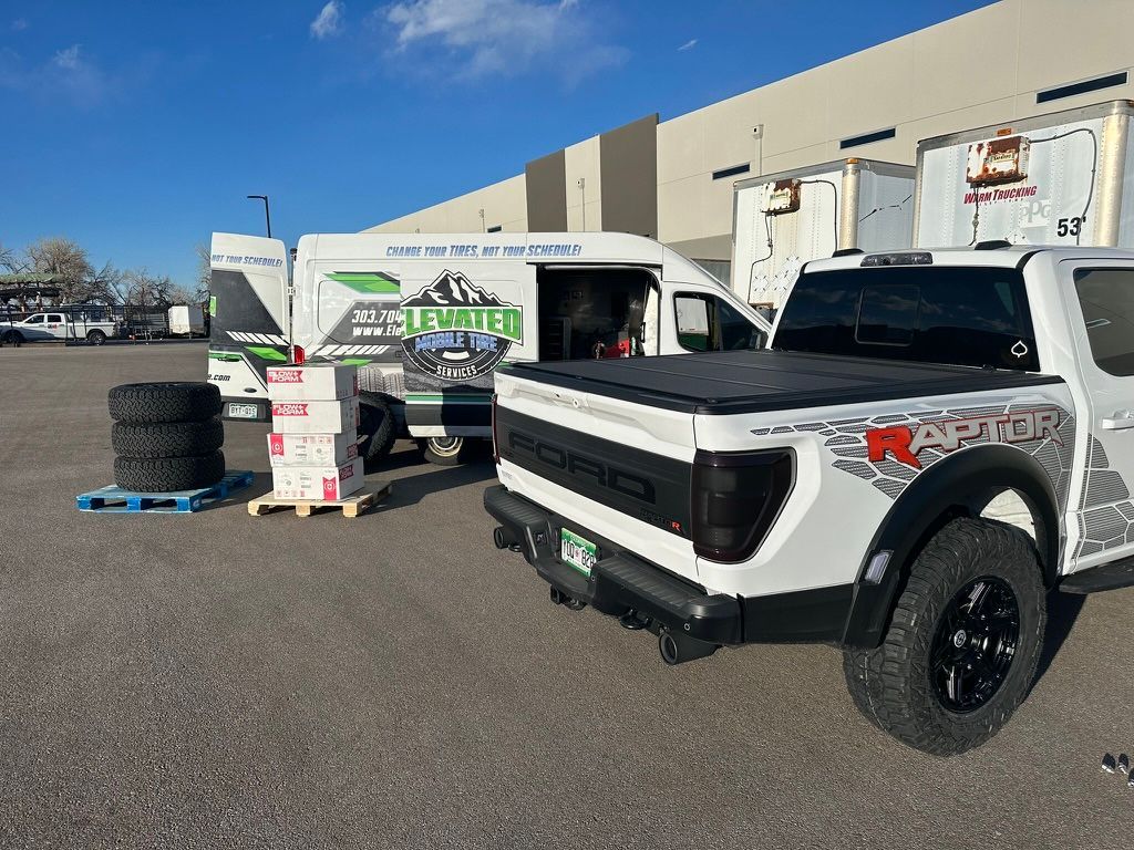 A white Raptor truck and a van with 