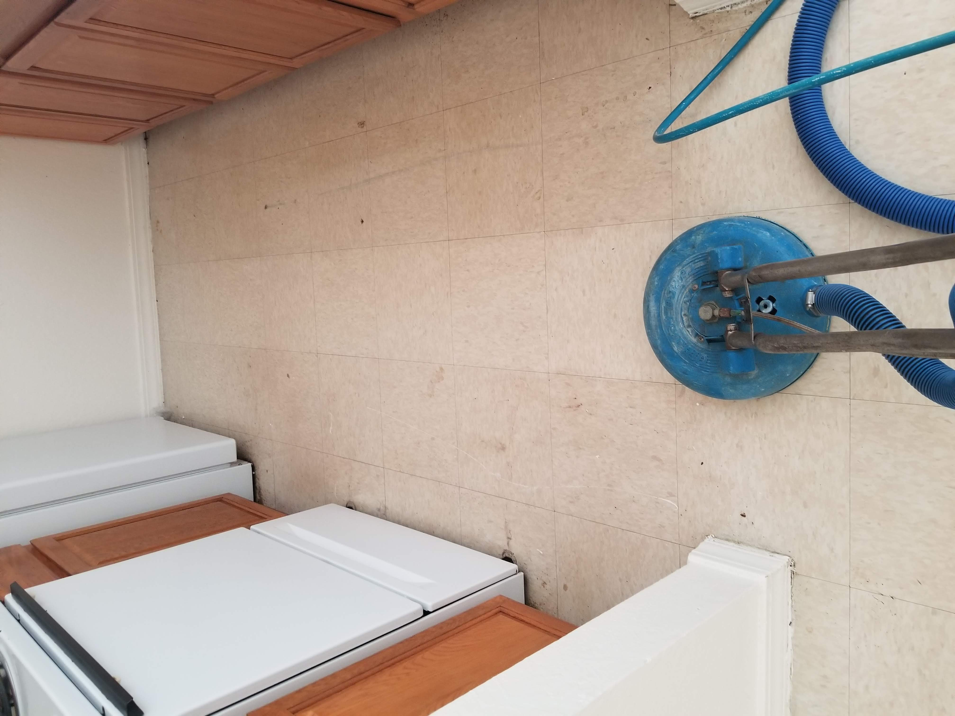 Tiled rooftop with white panels and a blue hose reel mounted on a beige wall