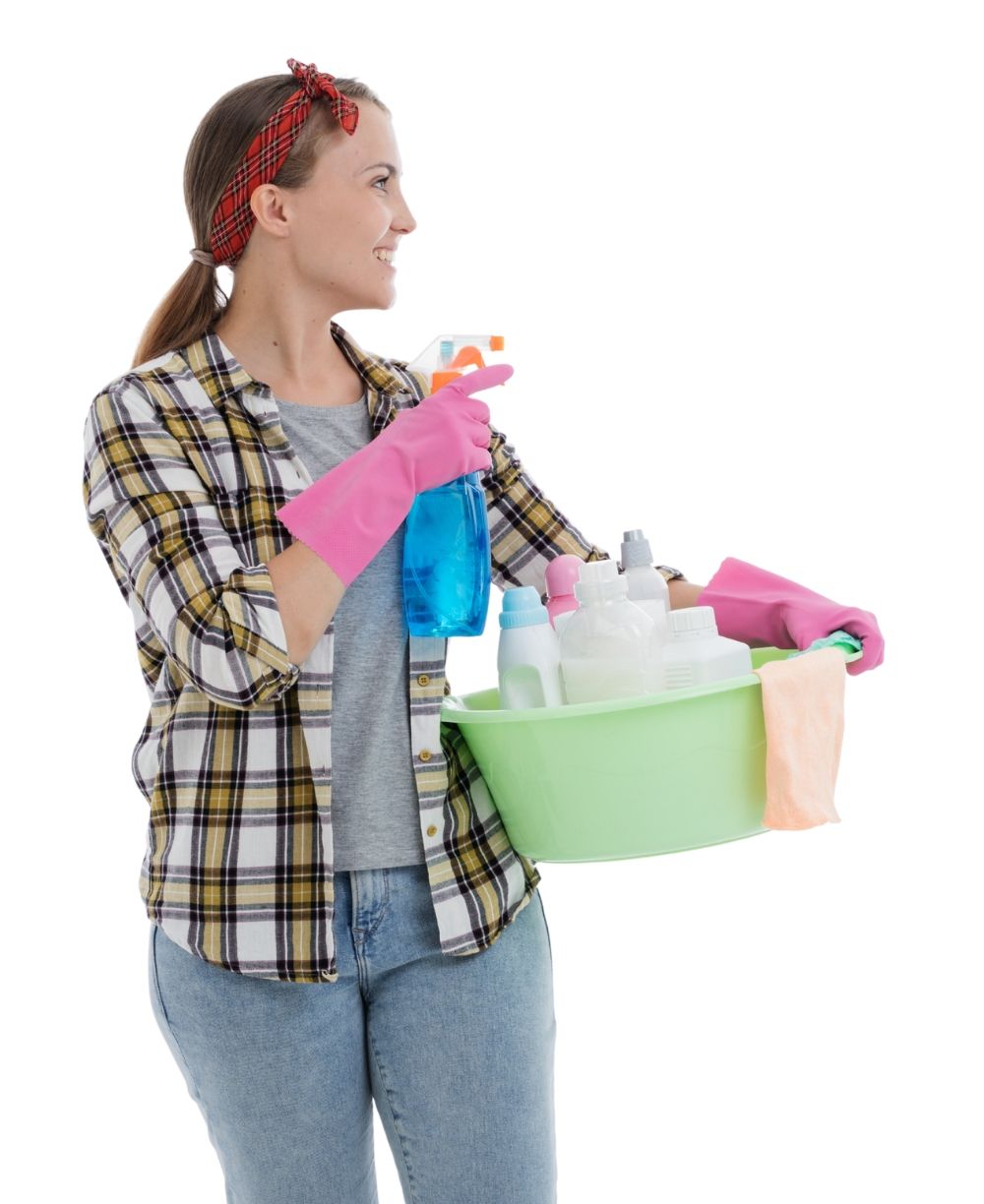 Person in pink gloves holding cleaning supplies and a bucket with bottles and spray cleaner
