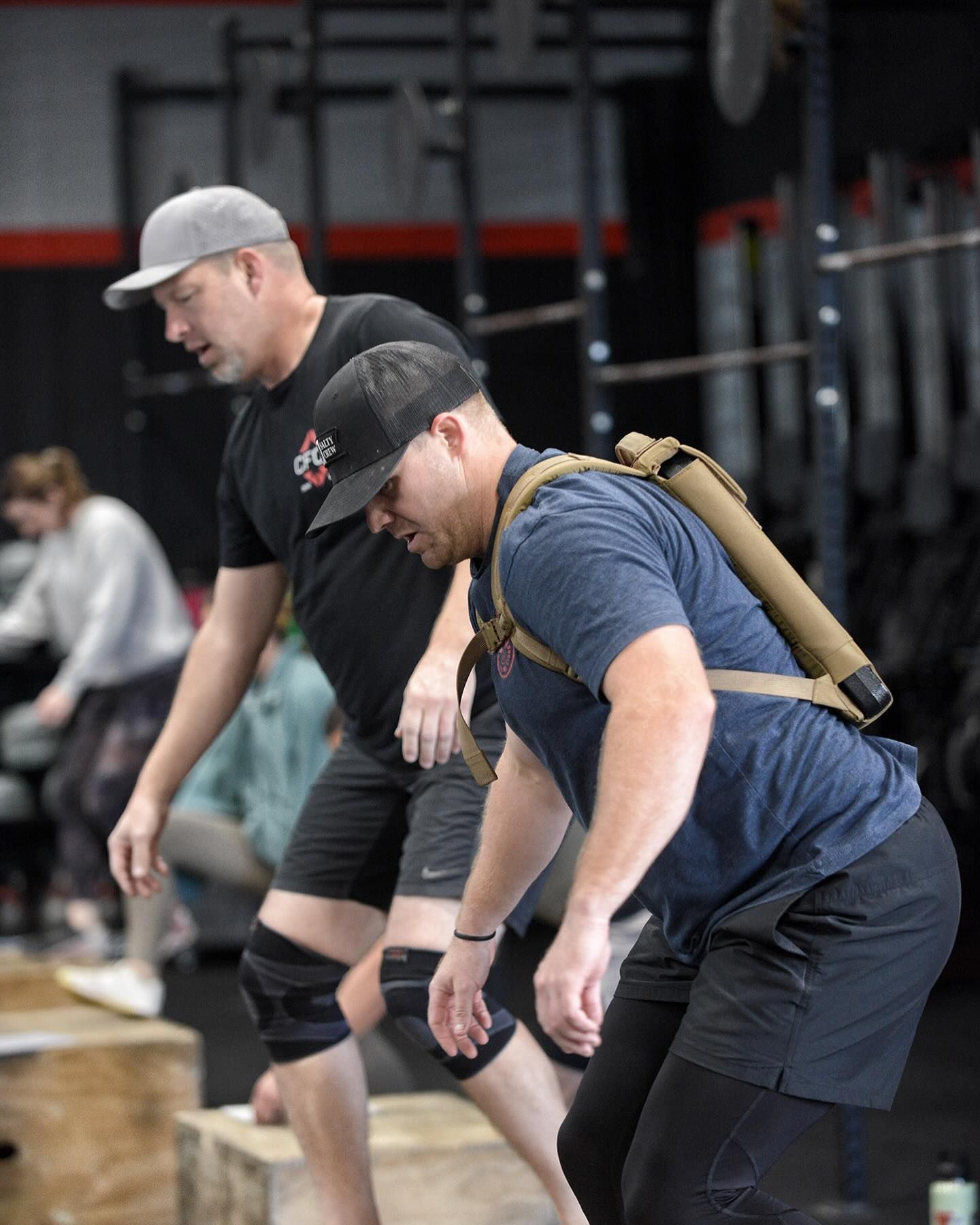 Two men are standing next to each other in a gym.
