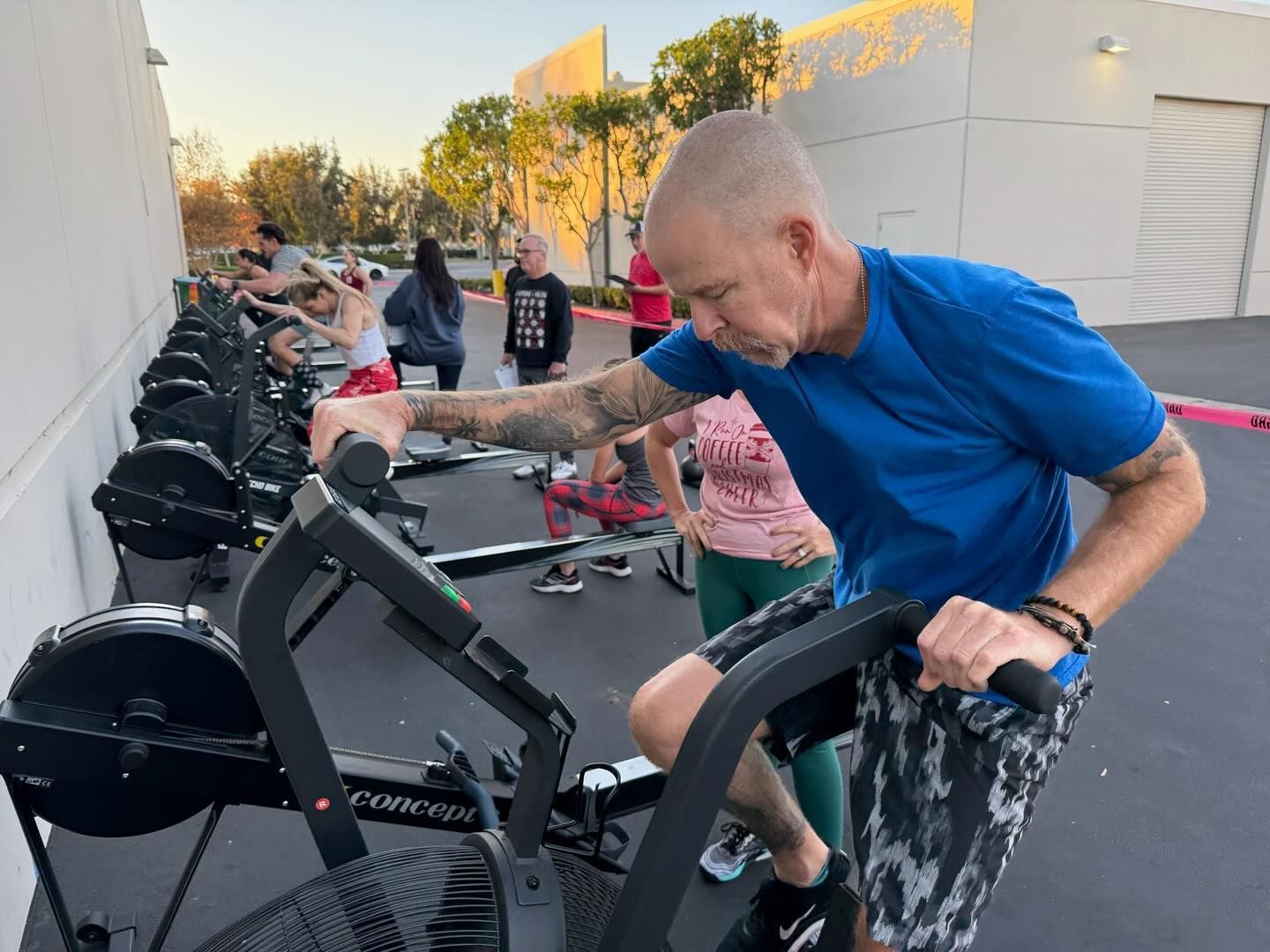 A man in a blue shirt is riding an exercise bike.