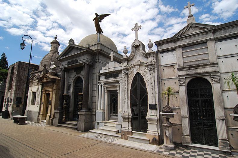 Un cementerio con una estatua de un ángel encima de uno de los edificios