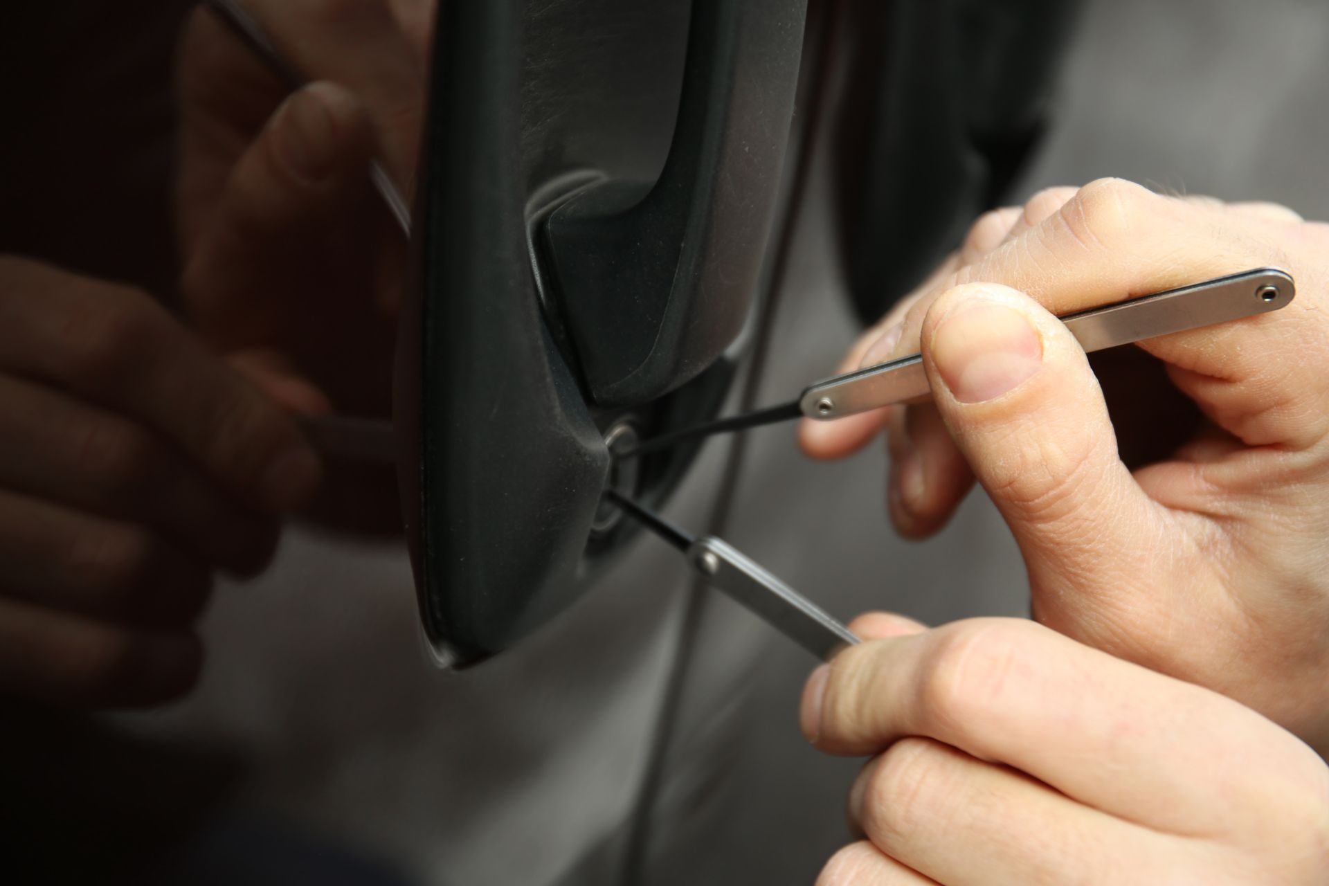Knapp lock and Safe: Skilled locksmith expertly picking the door lock of a vehicle with specialized tools to provide professional automotive locksmith services.