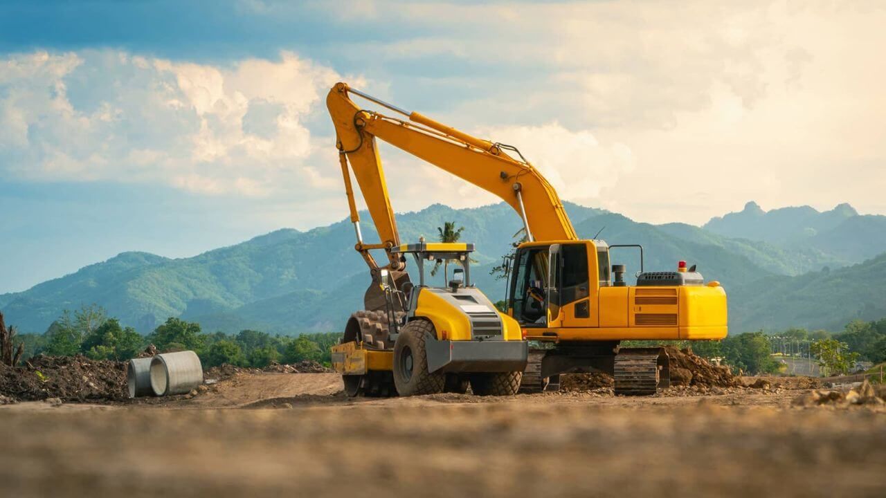 Construction machine operating on dirt field, leveling the ground.