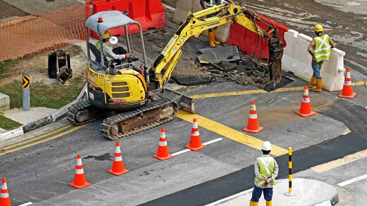 Road construction in progress, featuring workers and safety cones.