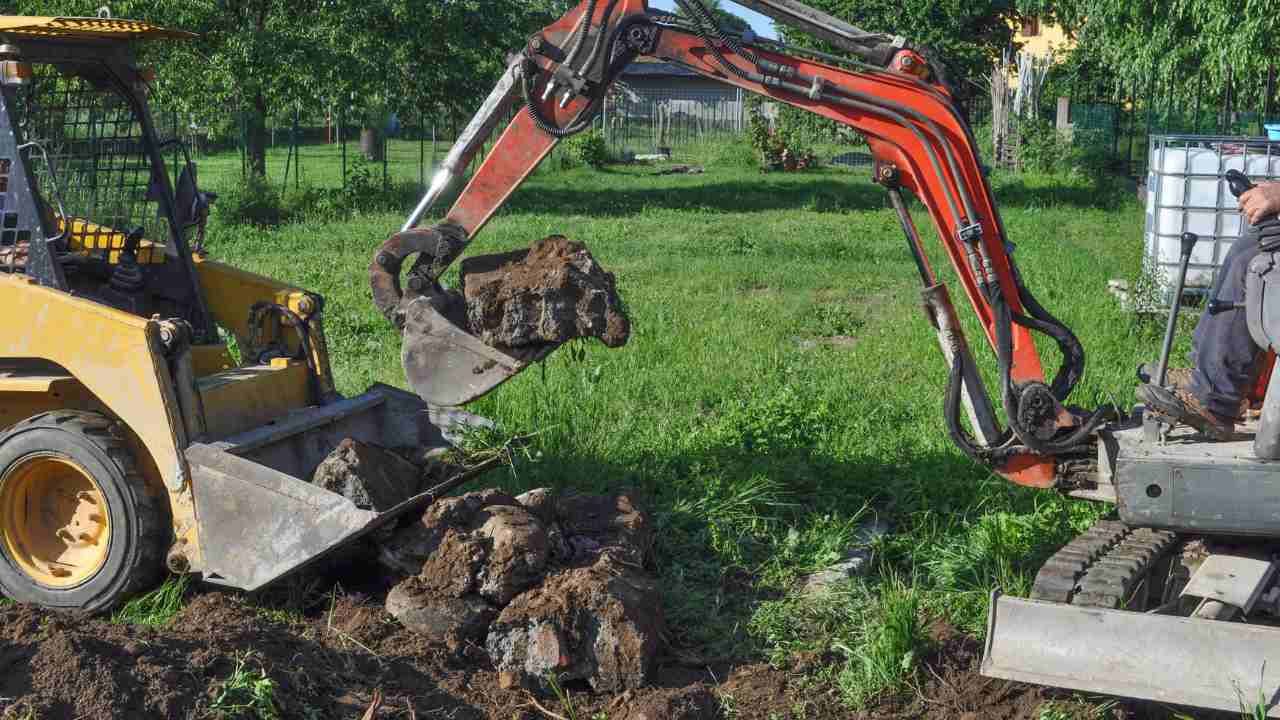 Backhoe operator excavating soil with heavy machinery.