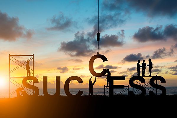 Silhouetted people building the word 