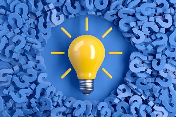 Yellow light bulb surrounded by blue question marks symbolizing ideas, answers, and problem solving