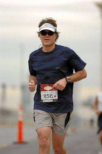 Runner wearing visor and sunglasses, running in a race with bib number 856.
