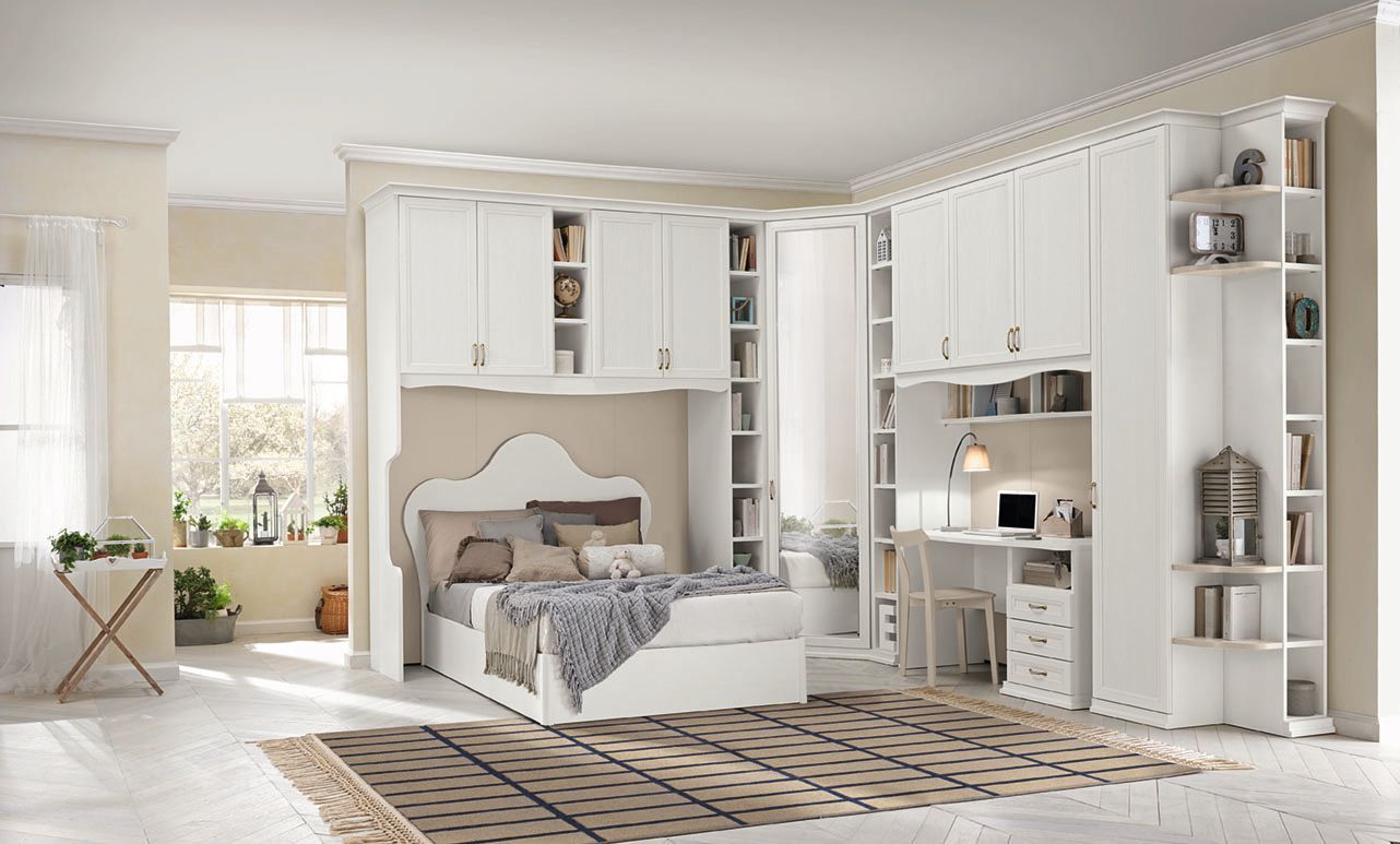 Camera da letto bianca con armadio a muro, scrivania e letto; tappeto sul pavimento, illuminazione.