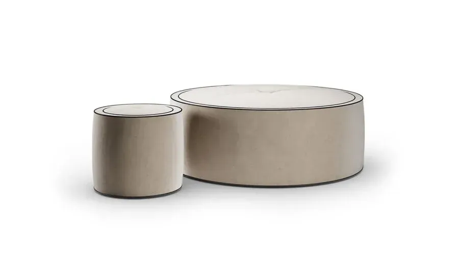 Due pouf rotondi imbottiti color beige con finiture scure.