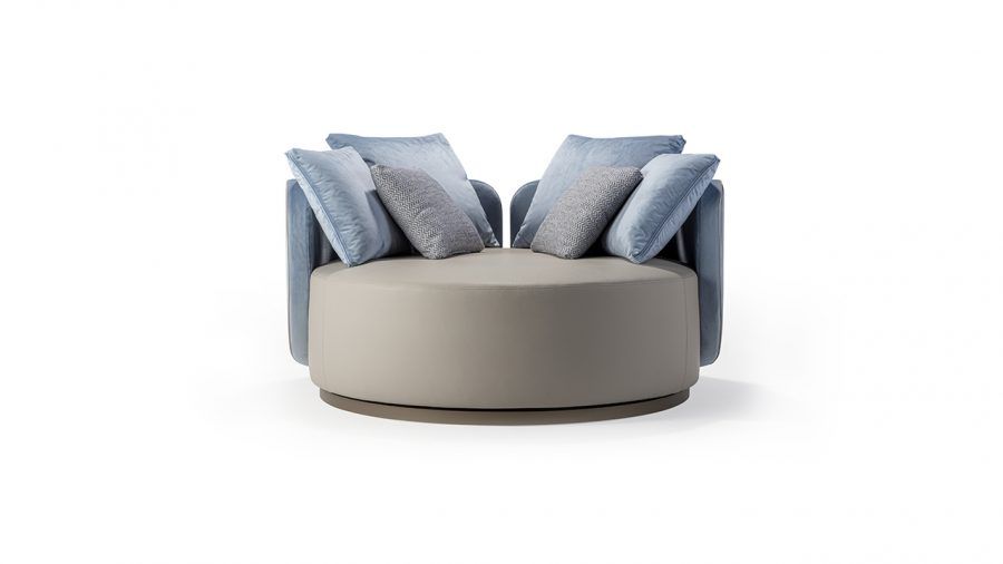 Sedia rotonda imbottita beige e blu con cuscini.