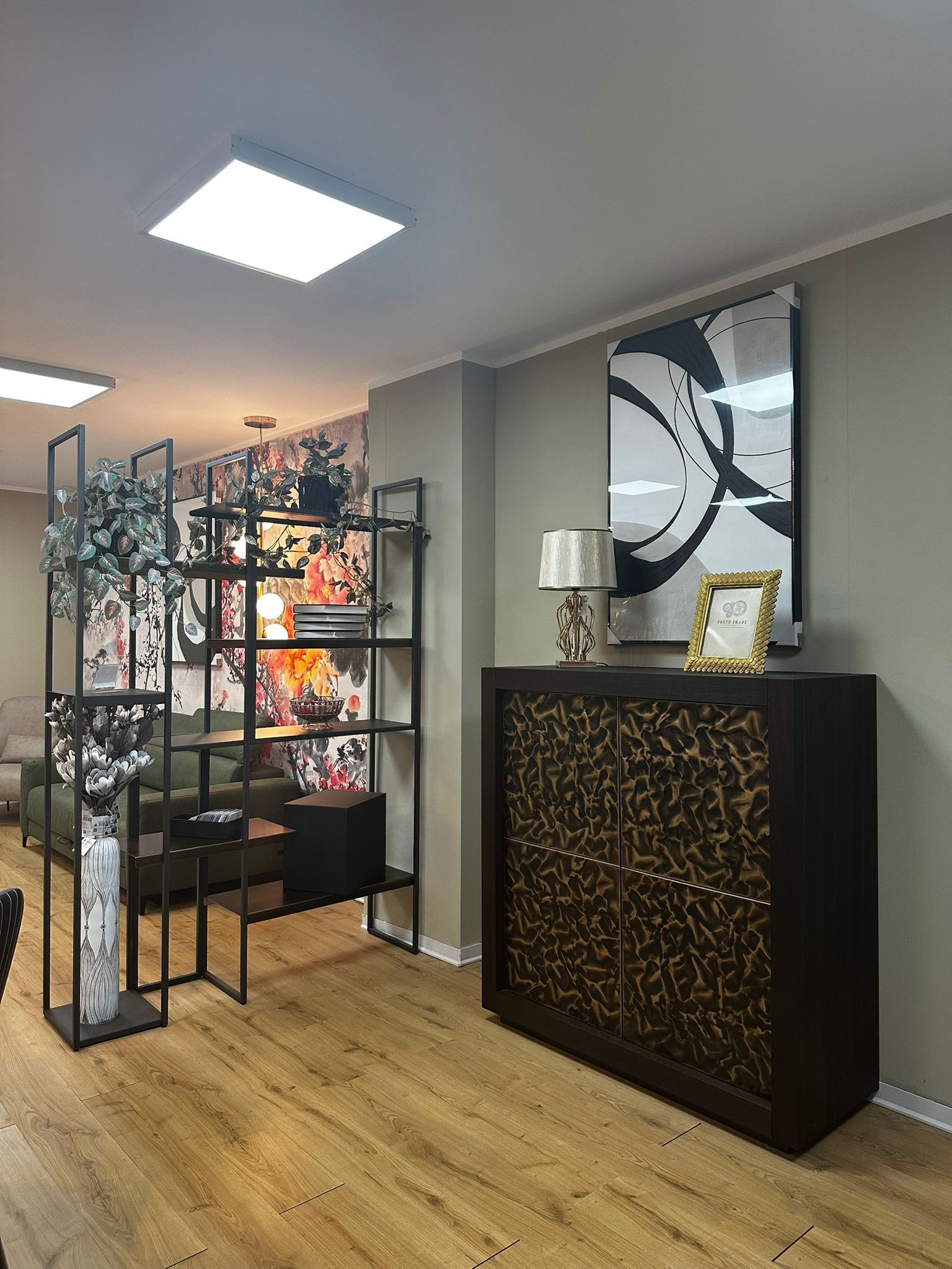 Una stanza con un mobile in legno scuro, scaffali e un paravento decorativo.