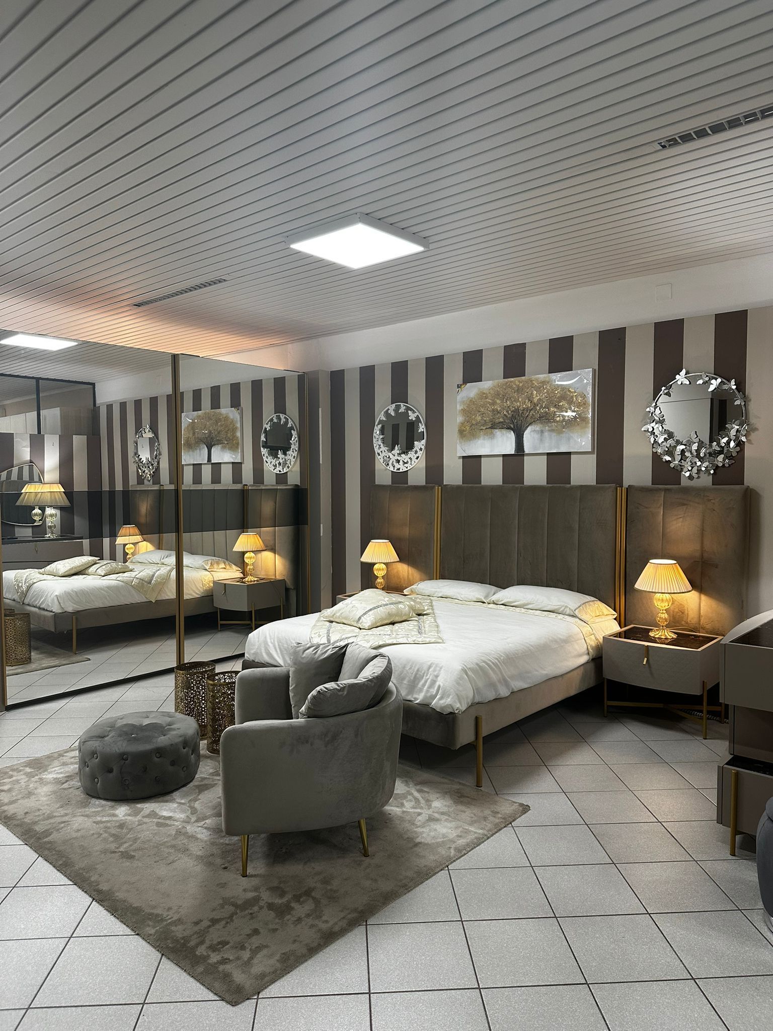 Una camera da letto moderna con letto, sedute e decorazioni in tonalità neutre.