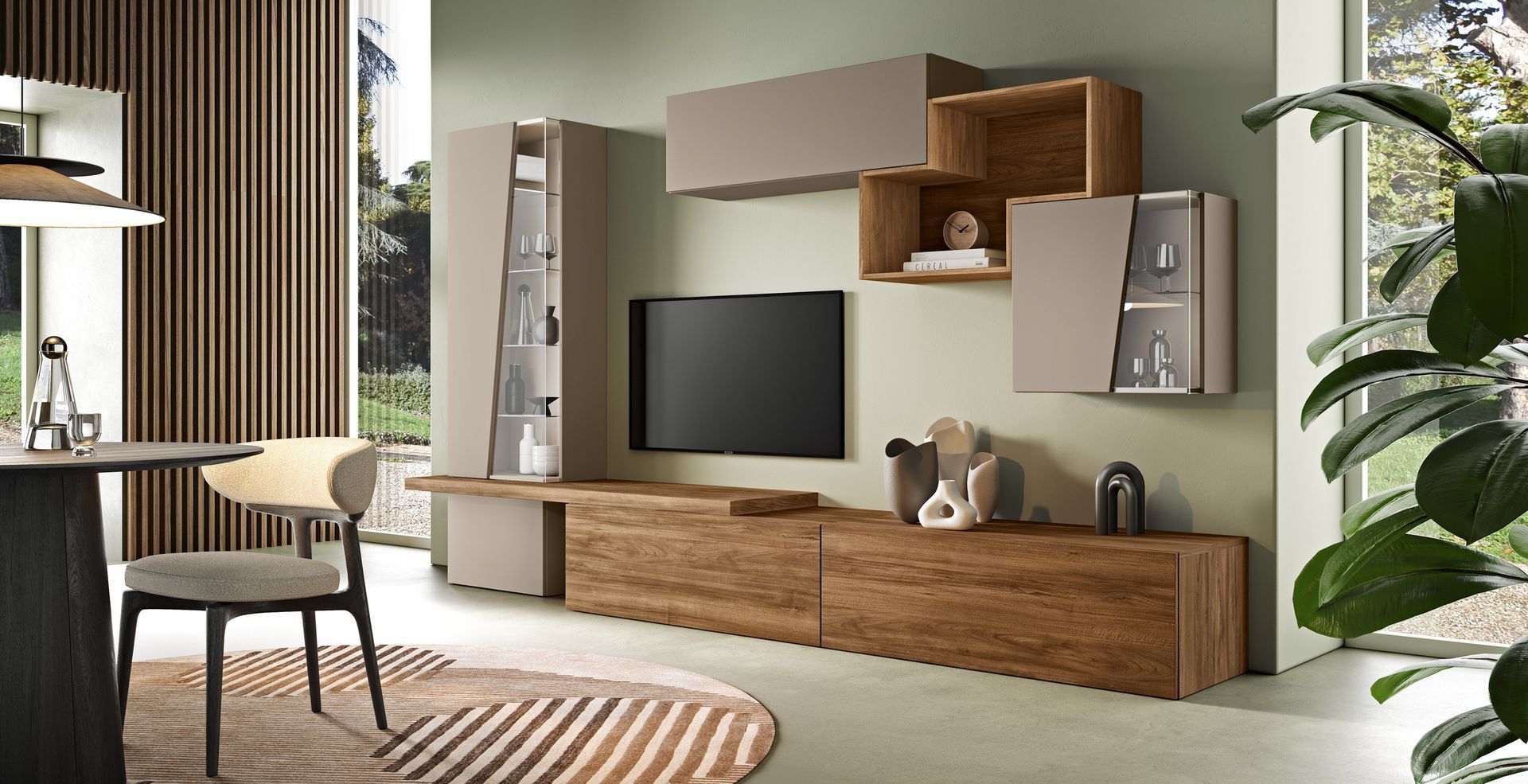 Soggiorno con mobili in legno, TV e mensole sospese su una parete verde salvia.