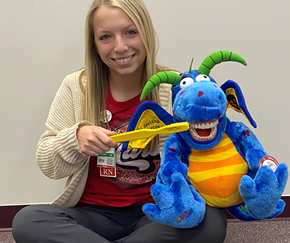 A woman is brushing her teeth with a stuffed animal