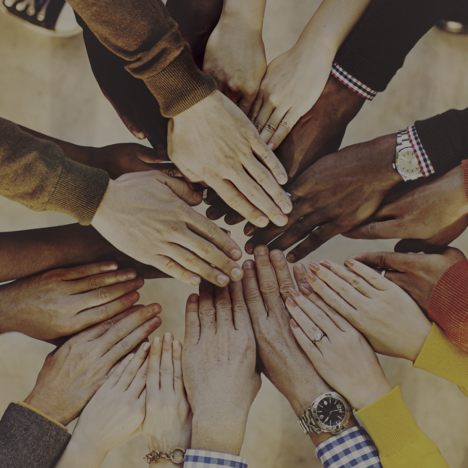 A group of people putting their hands together in a circle