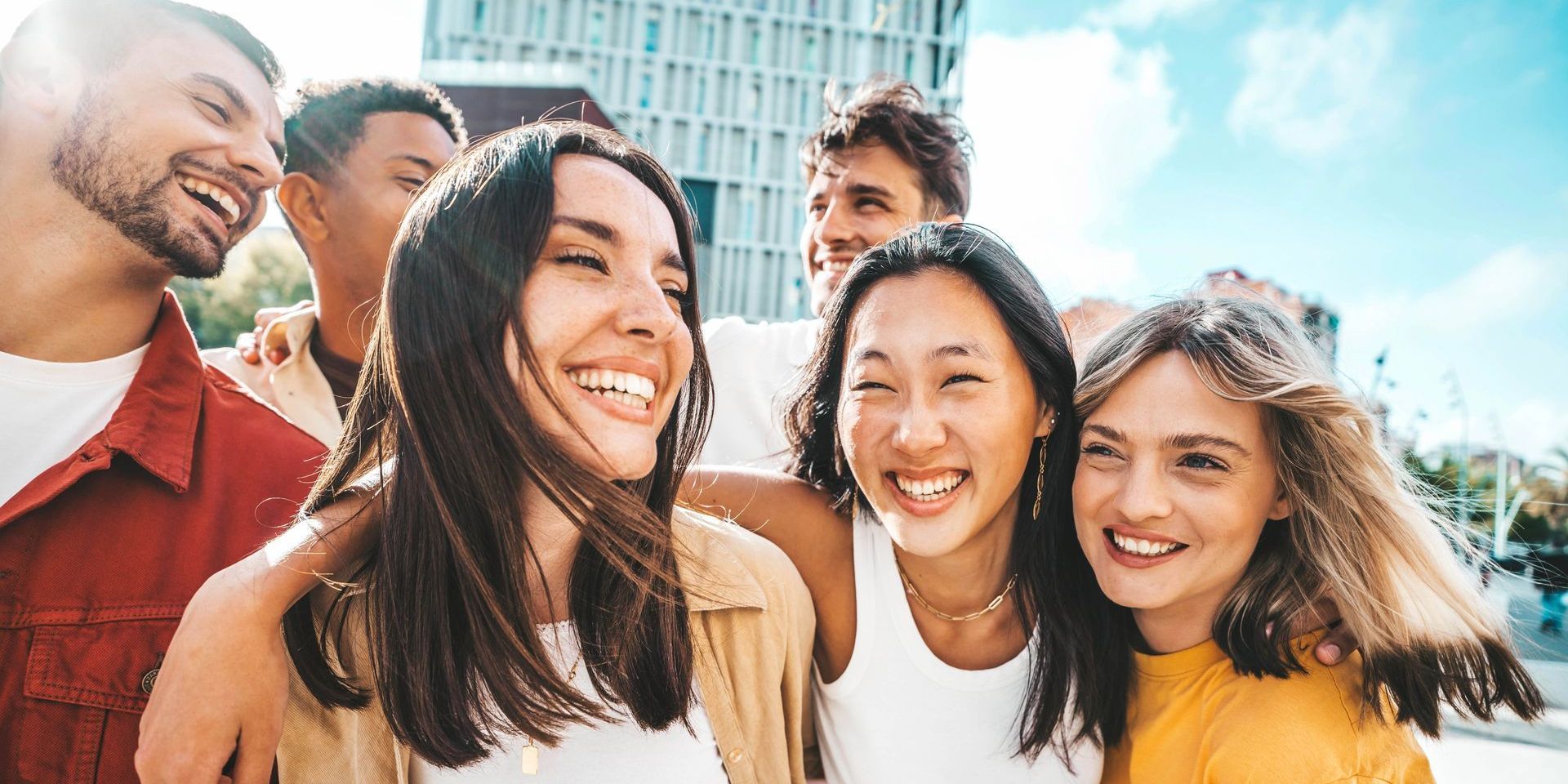 A group of young people are standing next to each other and smiling.