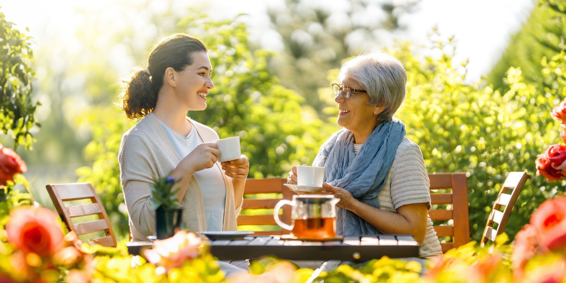 Two women are sitting at a table drinking tea.