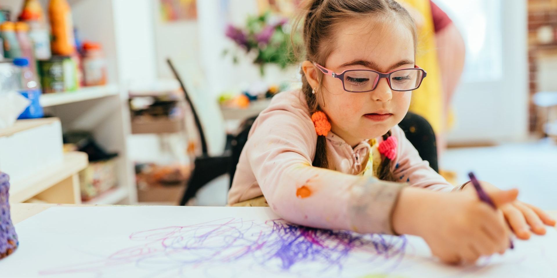 A girl with Down Syndrome coloring