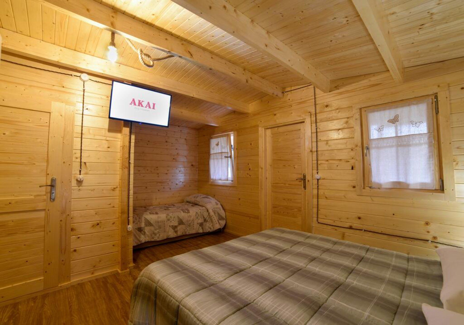 Una camera da letto in una baita di legno con un letto e una TV a schermo piatto.
