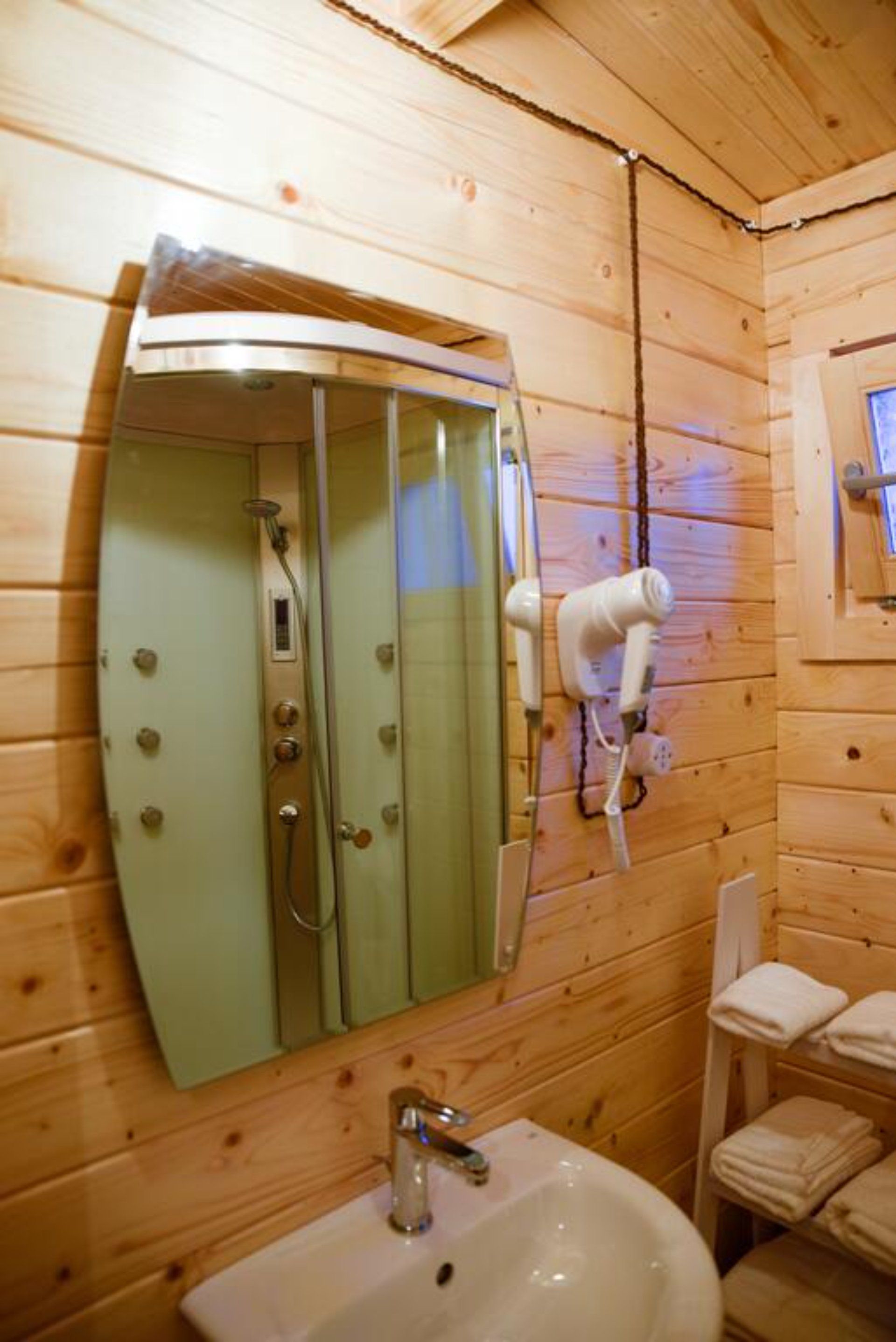 Un bagno con lavandino, specchio e asciugacapelli.