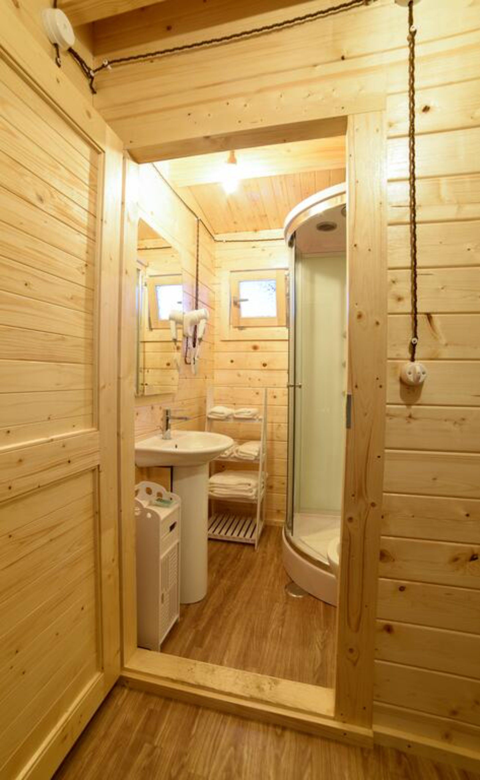 Un bagno in legno con lavandino, specchio e doccia.