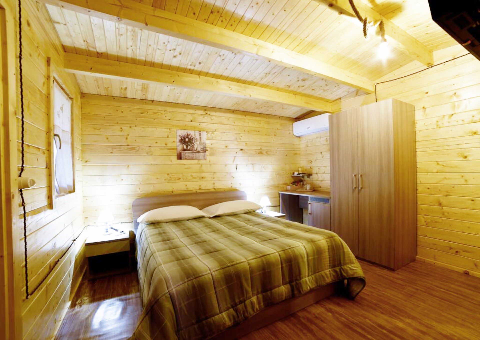 Una camera da letto con un letto e un armadio in una cabina di legno.