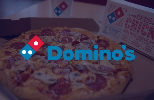 A domino 's pizza is in a box on a table.