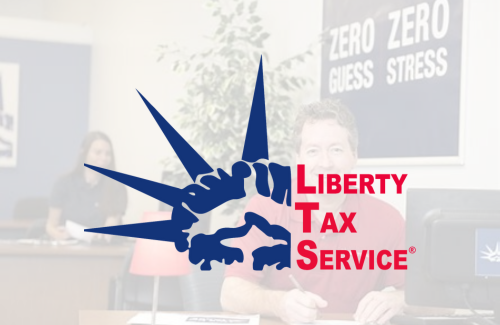 A man sits at a desk in front of a sign that says zero zero guess stress