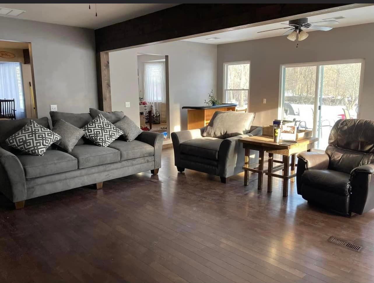 A living room with a couch , chair , table and sliding glass doors.