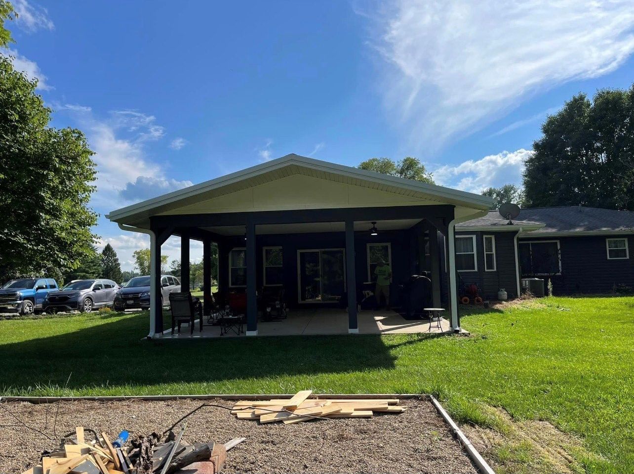 A house with a porch and a fire pit in front of it.
