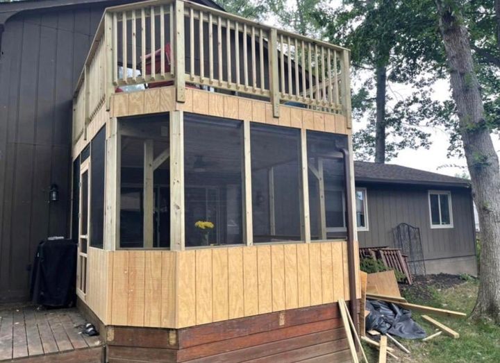 A screened in porch is being built on the side of a house.