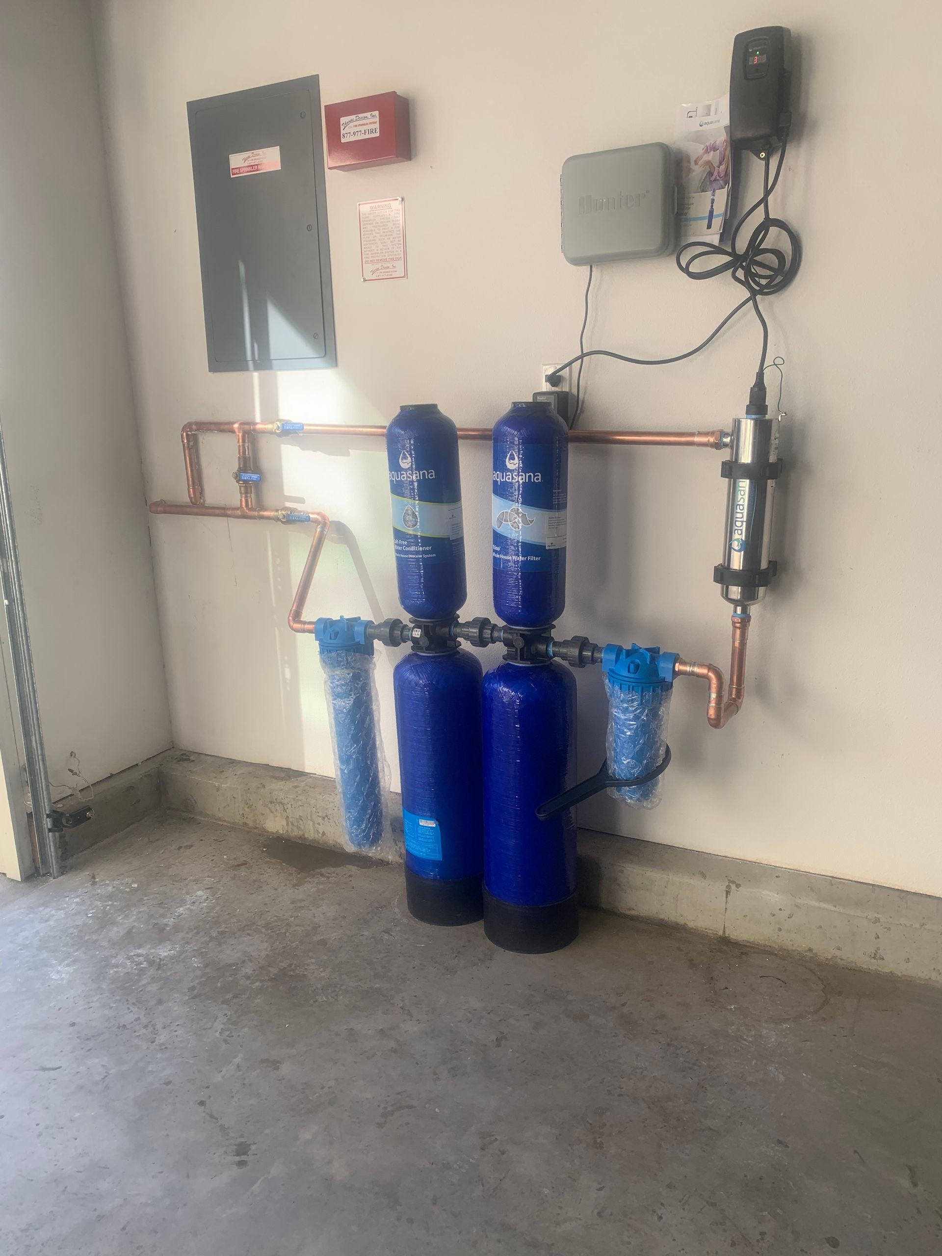 Two blue tanks are sitting next to each other in a garage.