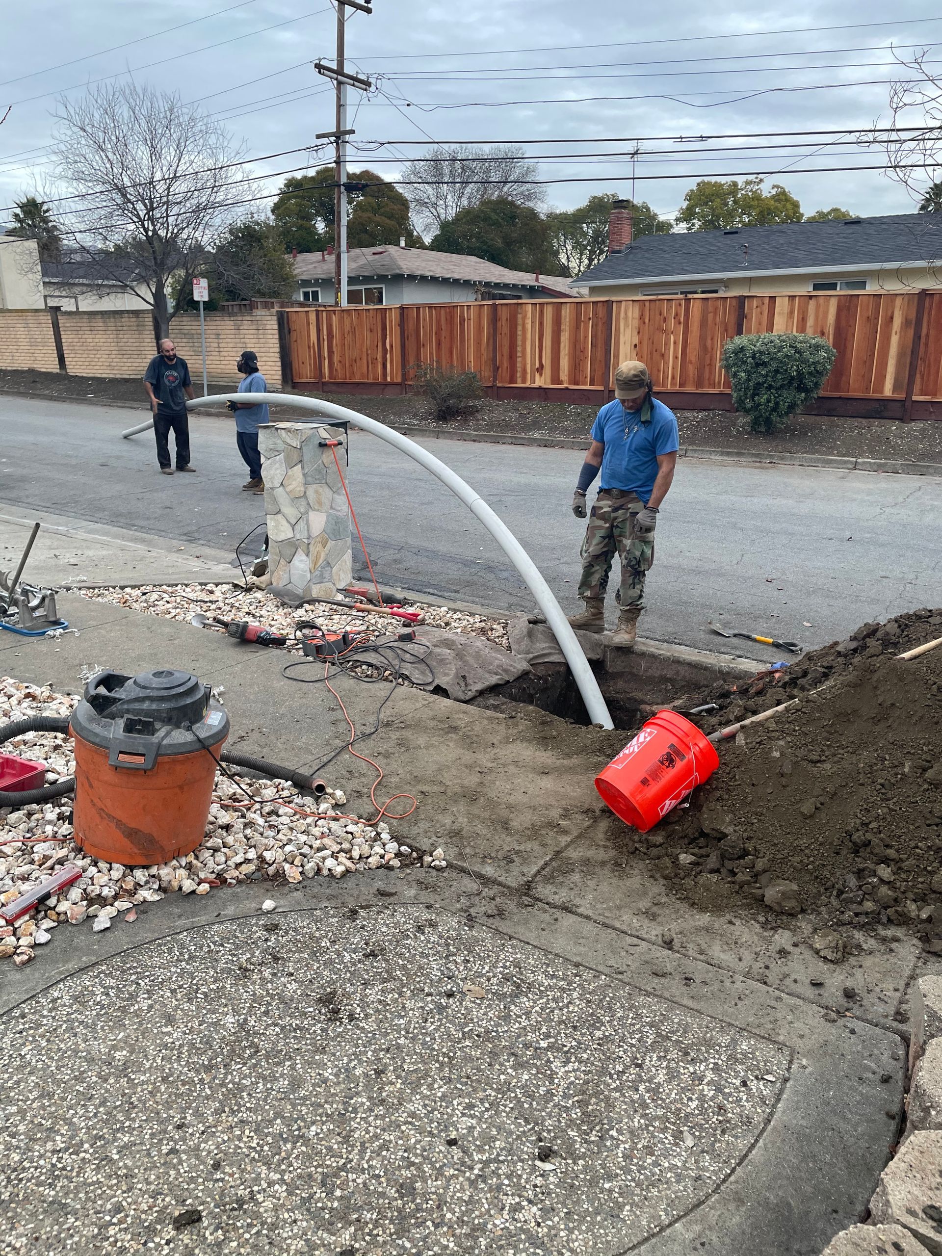 A man is pumping water into a hole in the ground.
