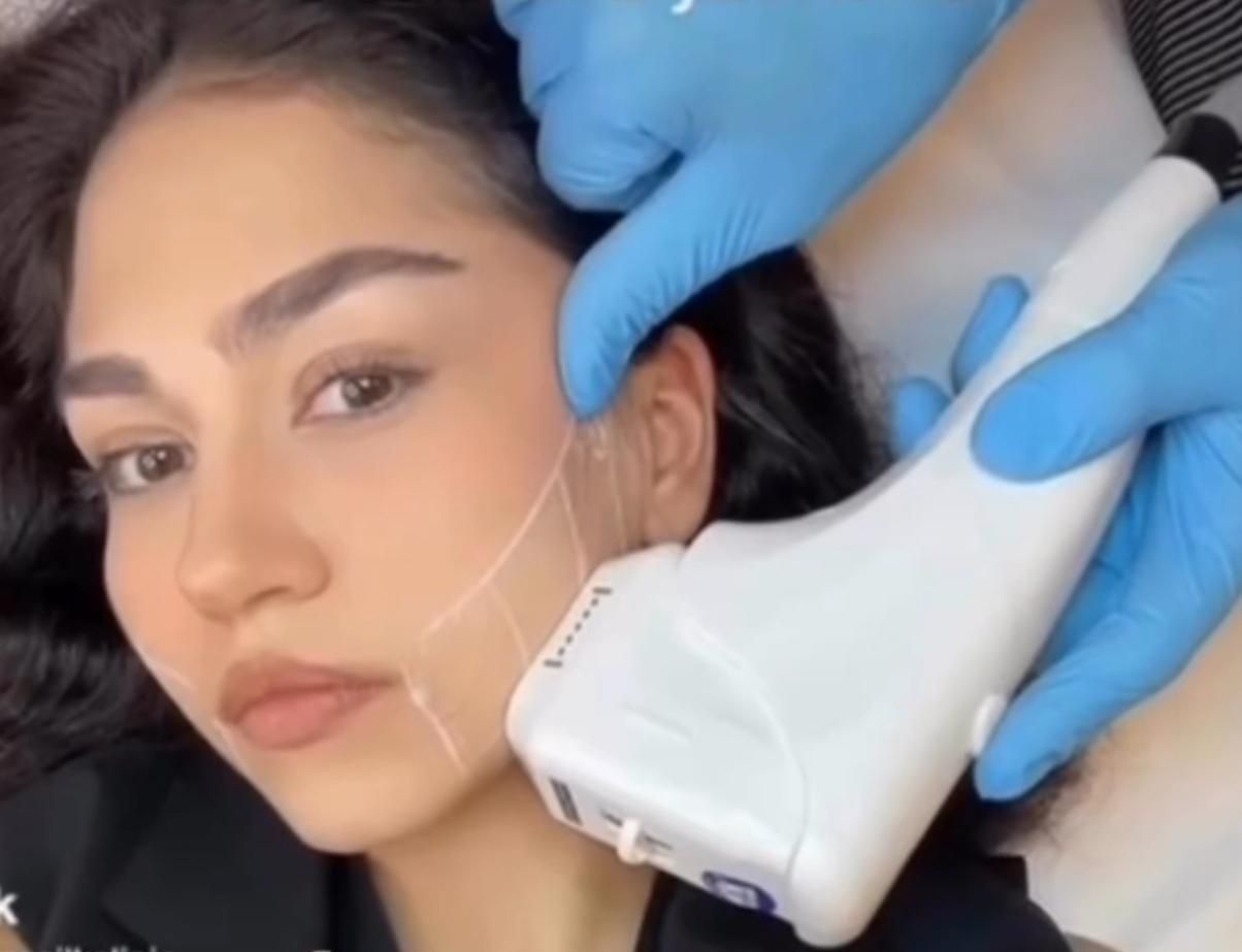 A woman is getting a facial treatment at a beauty salon.