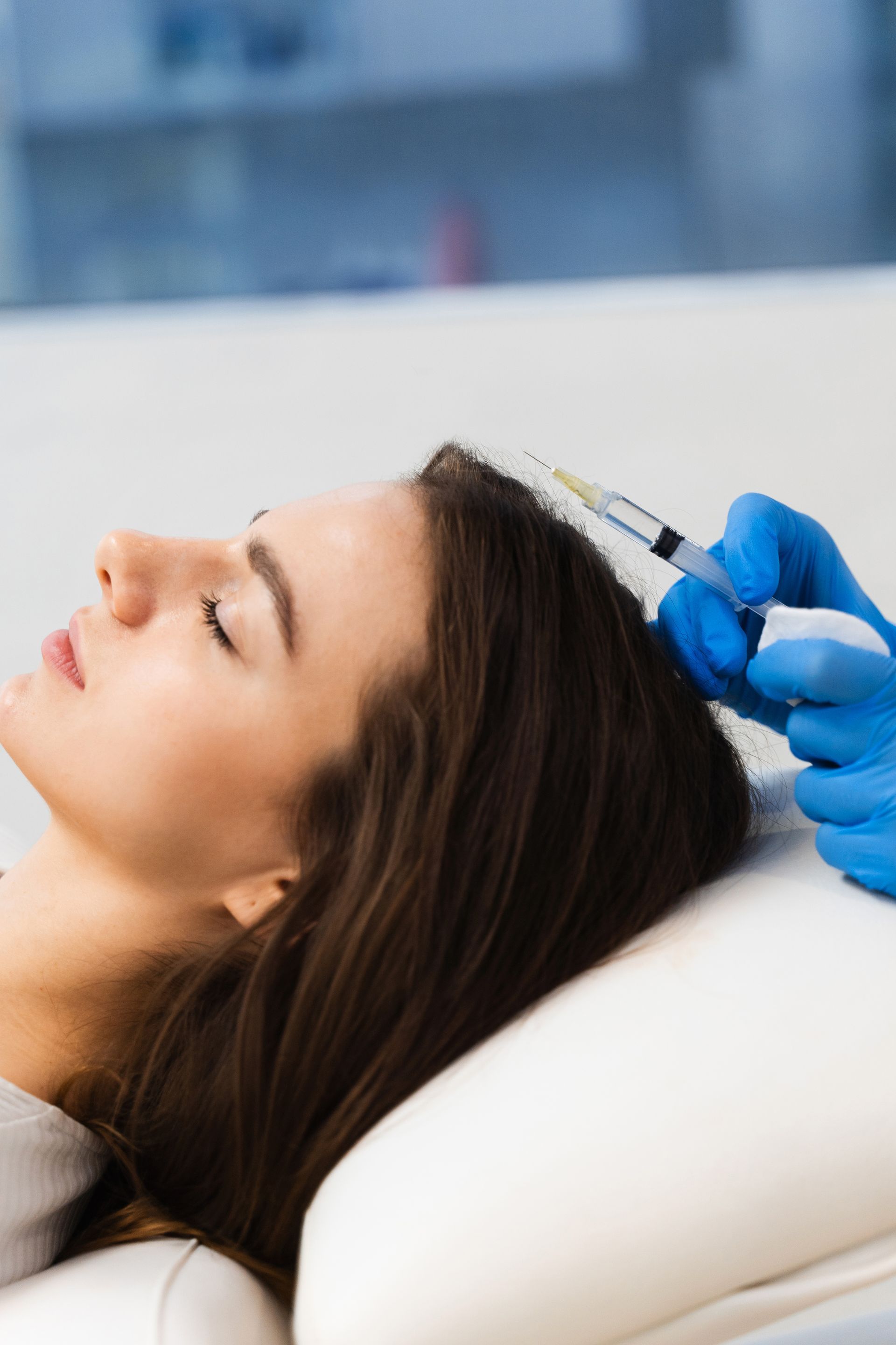 A woman is getting a botox injection in her head.