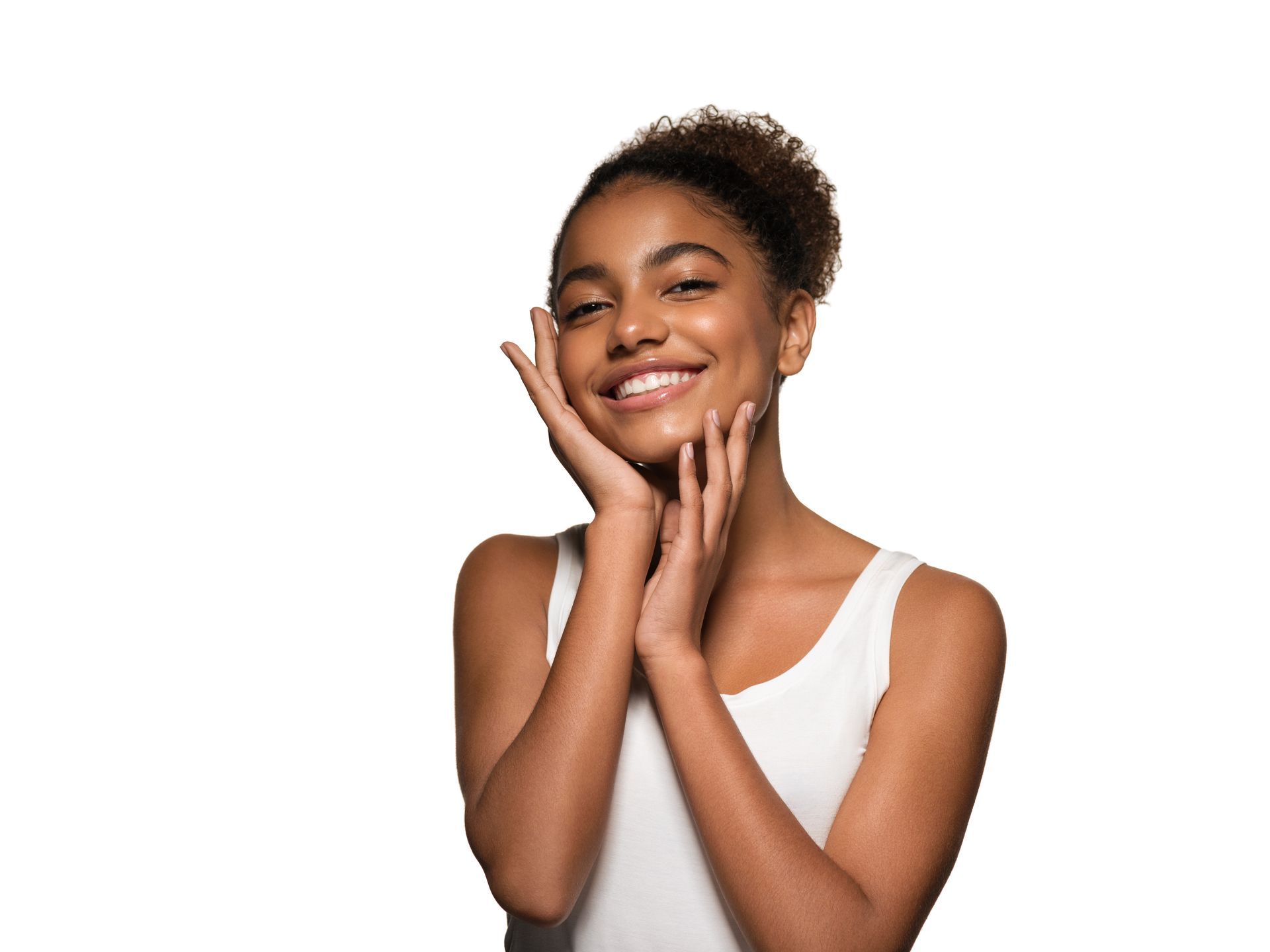 A woman is smiling and touching her face with her hands.