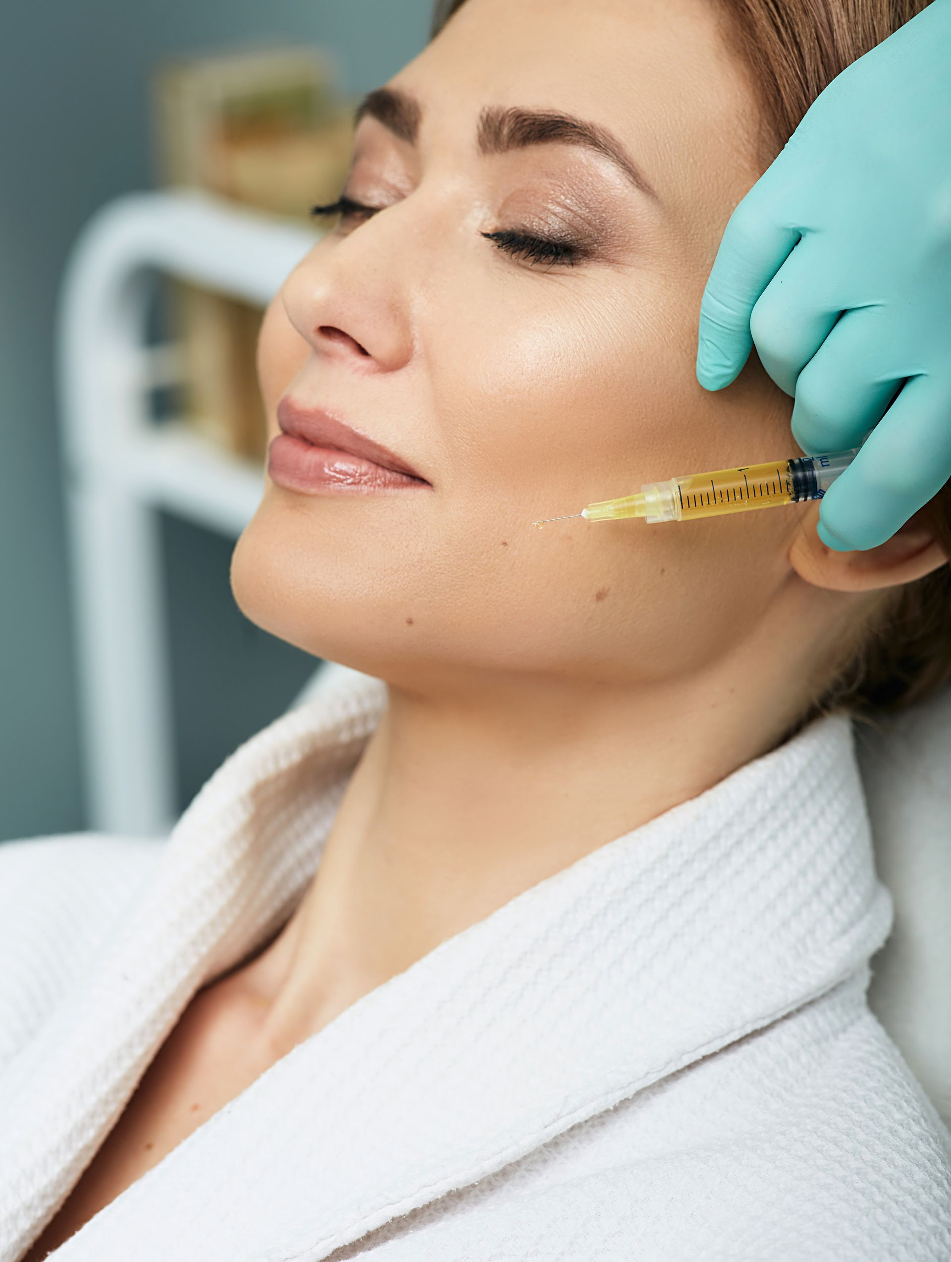 A woman is getting a botox injection in her face.