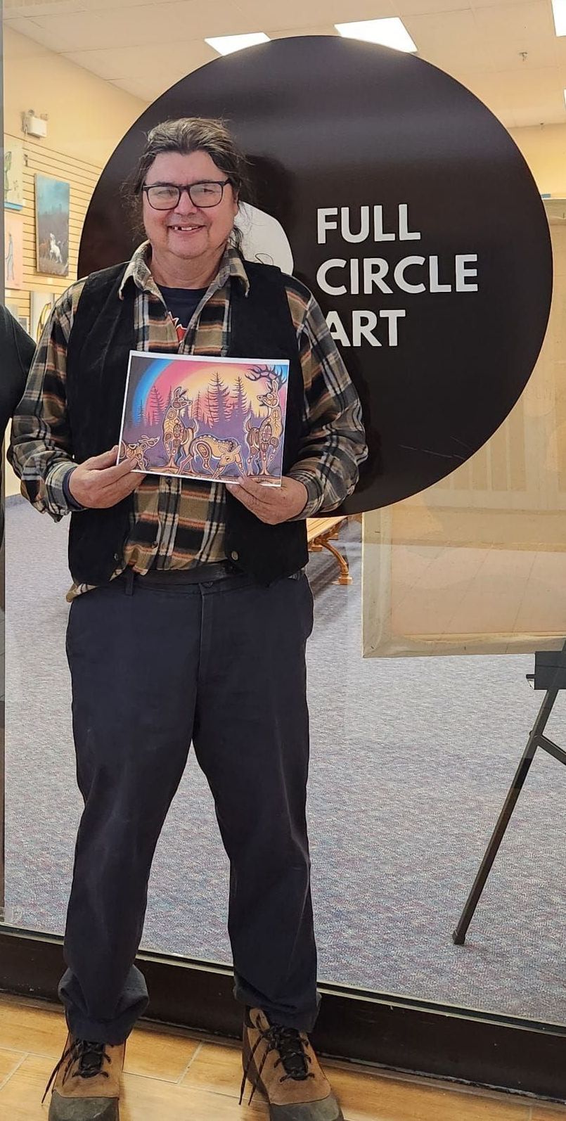 A man standing in front of a sign that says full circle art