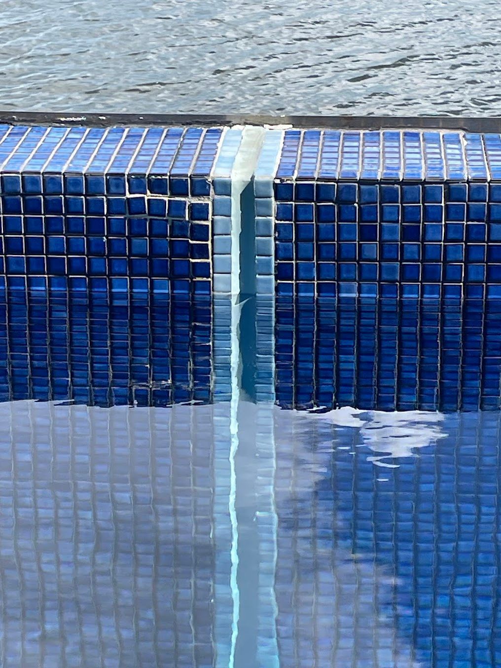 Blue Tiled Pool Edge With Water, Reflecting the Sky and Tiles — Leak N Pool In Southport, QLD