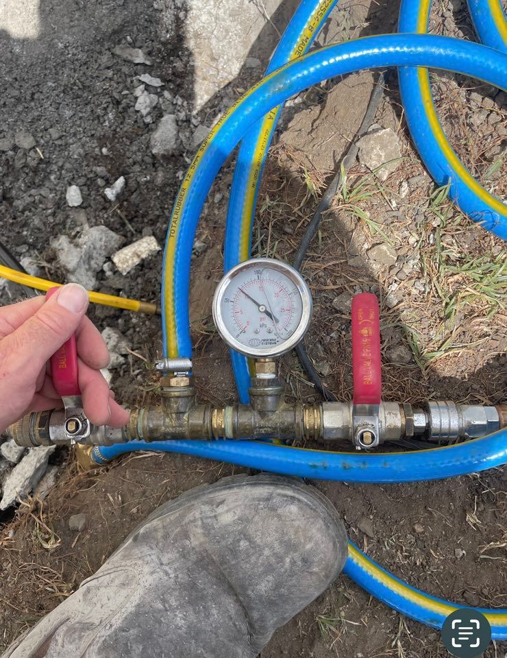 A Person's Hand Turns a Valve on a Blue Hose Connected to a Gauge — Leak N Pool In Tweed Shire, NSW