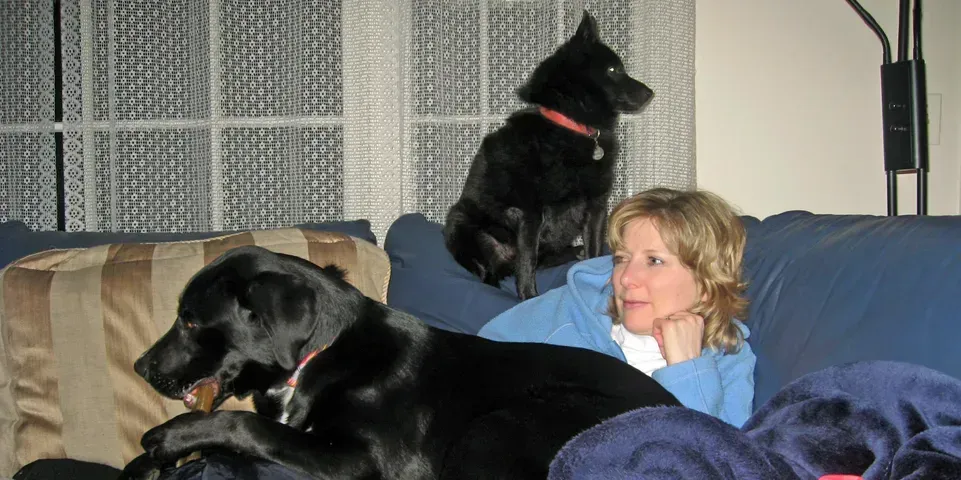 A woman with her dog lying in the bed