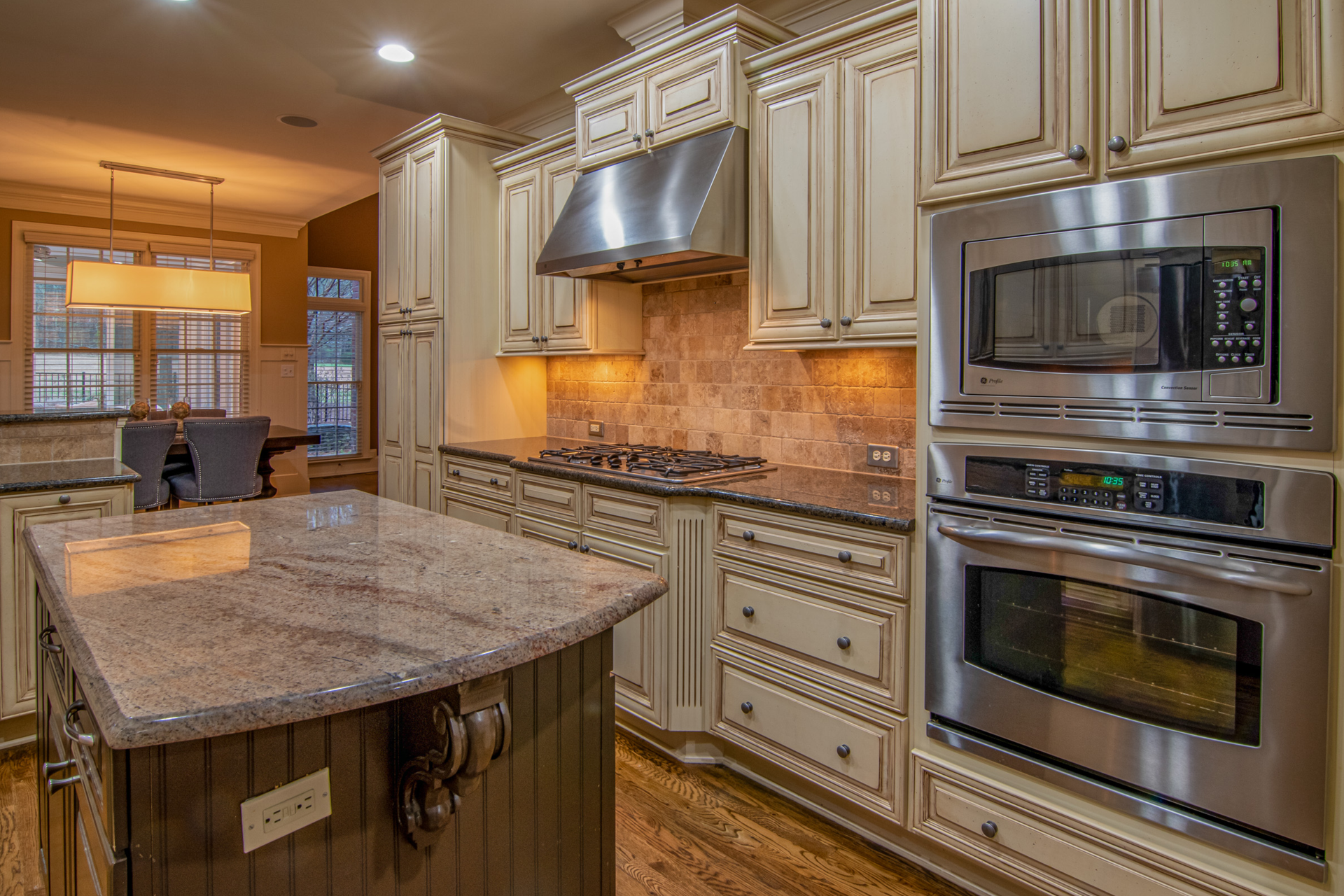 Rustic kitchen with light brown stained cabinets and a dark granite countertop.