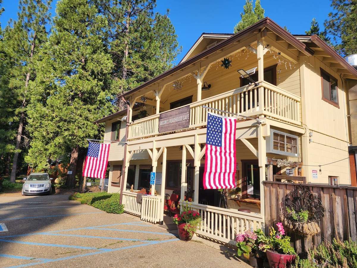 A large house with two american flags on the porch.