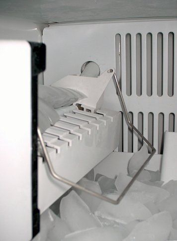 An ice maker sitting on a kitchen countertop, ready to produce ice cubes.