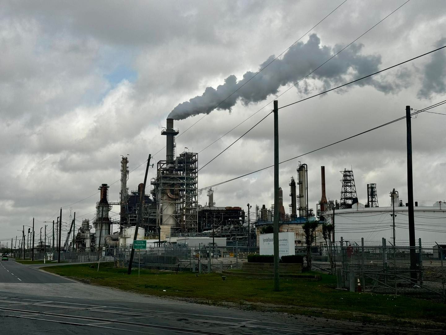 Industrial plant emitting smoke into cloudy sky.